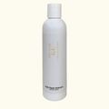 White shampoo bottle with 'The Glow Collection' branding on a white background